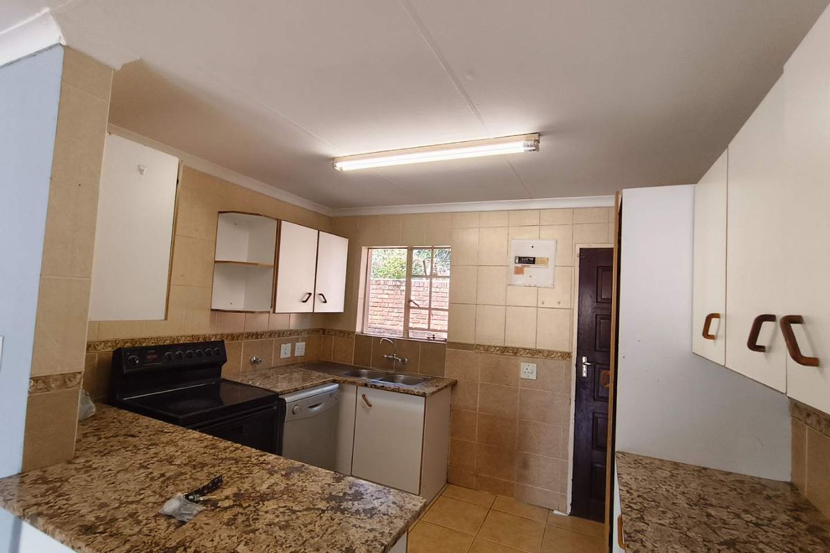 A functional kitchen featuring granite countertops, tiled backsplash, and ample built-in cabinetry, offering a practical layout ready for modernization.