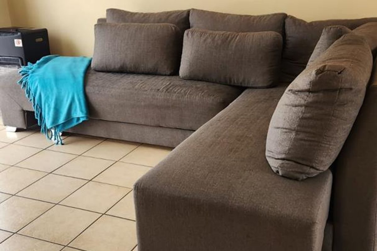 A living room area featuring neutral wall finishes and tiled flooring.