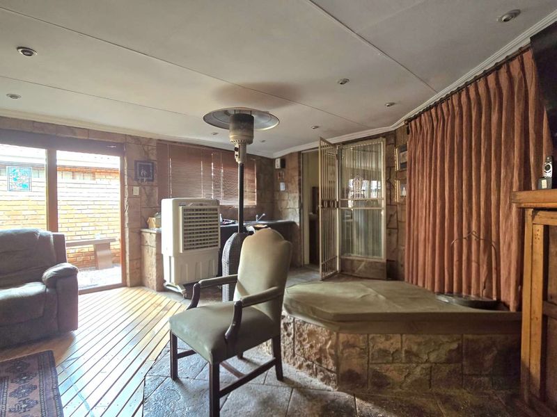 Spacious living area featuring stone-clad walls, recessed lighting, and direct access to an outdoor patio through sliding glass doors.