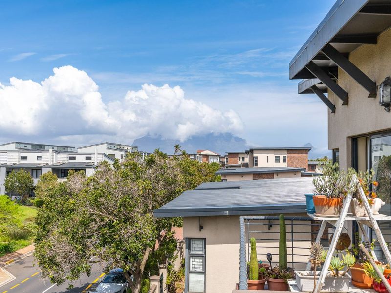 Elevated view from a balcony overlooking the surrounding residential neighborhood with a mountain backdrop.
