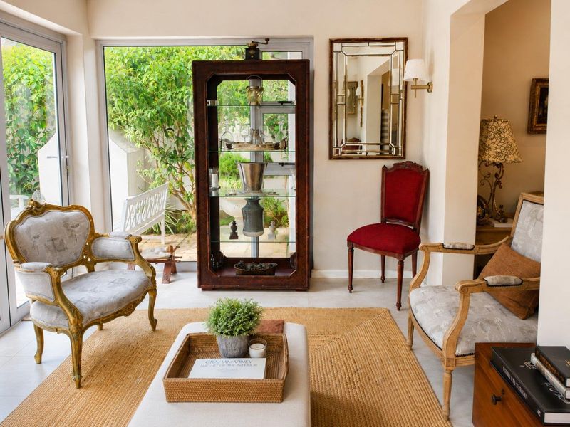 A bright and elegant living area featuring large glass sliding doors that provide seamless access to the garden and abundant natural light.