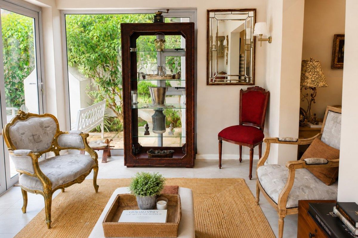 A bright and elegant living area featuring large glass sliding doors that provide seamless access to the garden and abundant natural light.