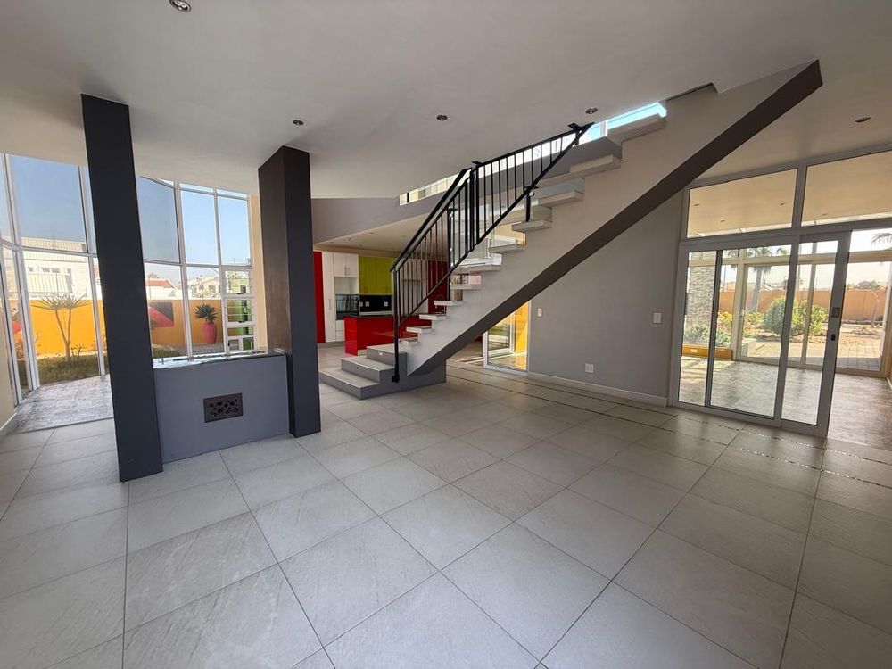 Second living area behind the staircase with a fireplace