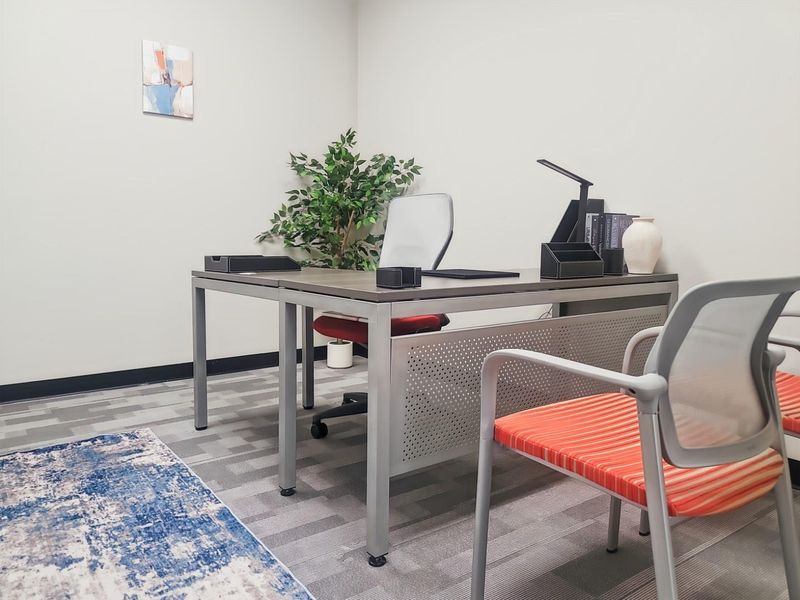 A professional office space featuring neutral wall finishes, durable carpet tiles, and clean architectural lines suitable for a productive work environment.