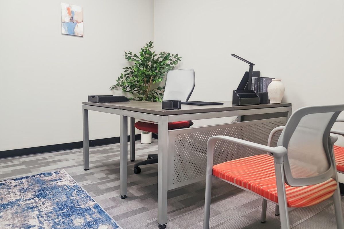 A professional office space featuring neutral wall finishes, durable carpet tiles, and clean architectural lines suitable for a productive work environment.