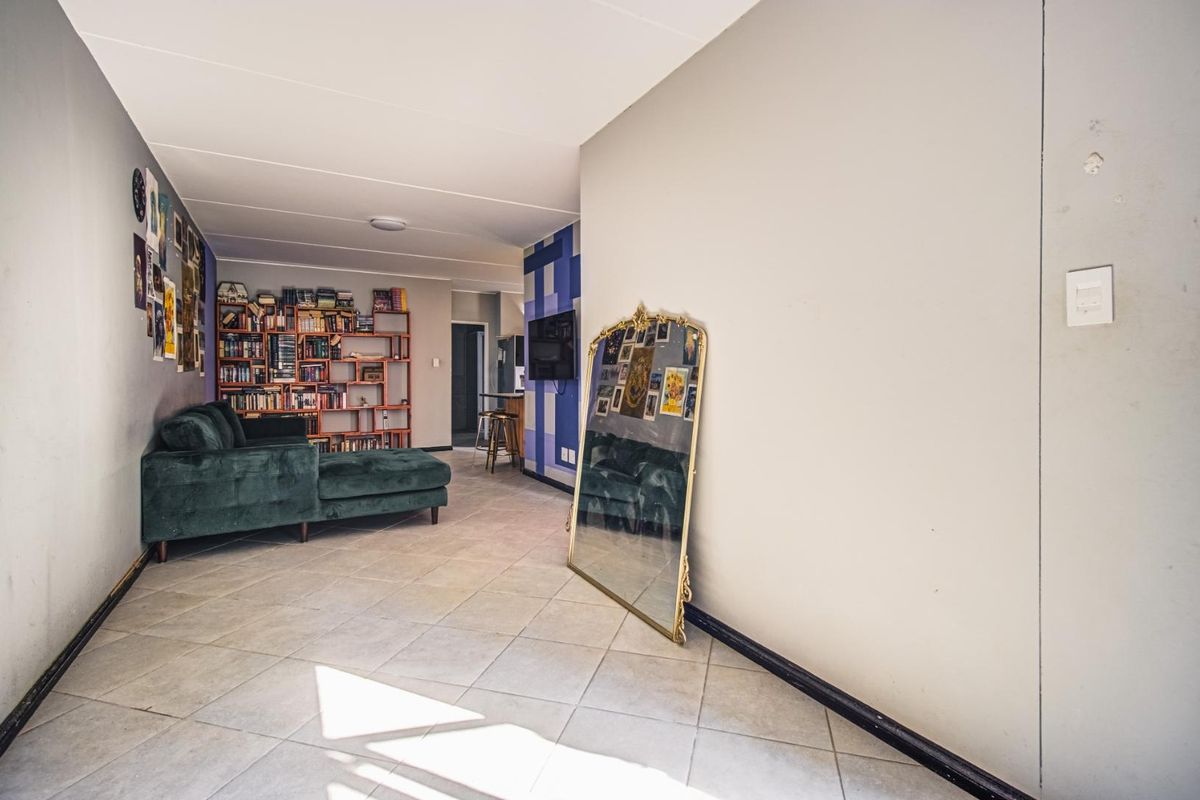 Open-plan living area featuring neutral tiled flooring and painted walls, providing a versatile space for relaxation and daily living.