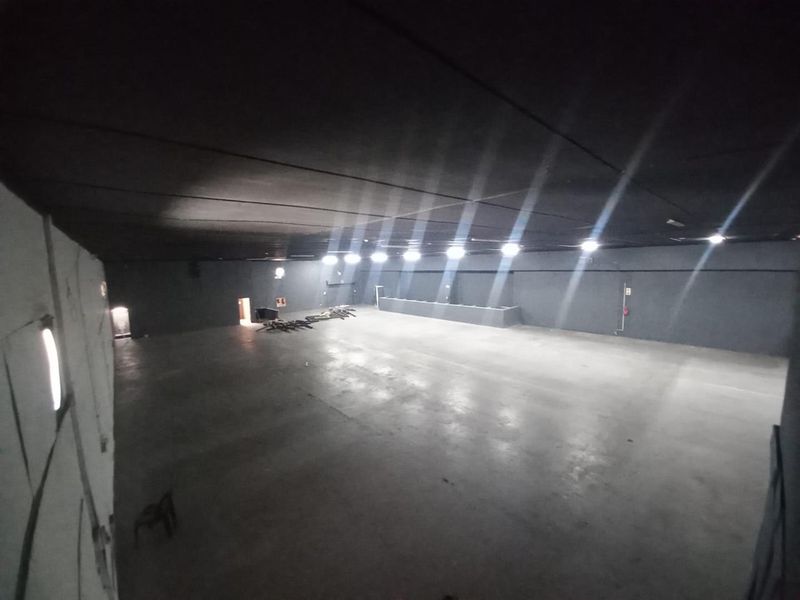 A large, open-plan industrial utility space featuring concrete flooring and recessed lighting, suitable for various commercial or storage applications.
