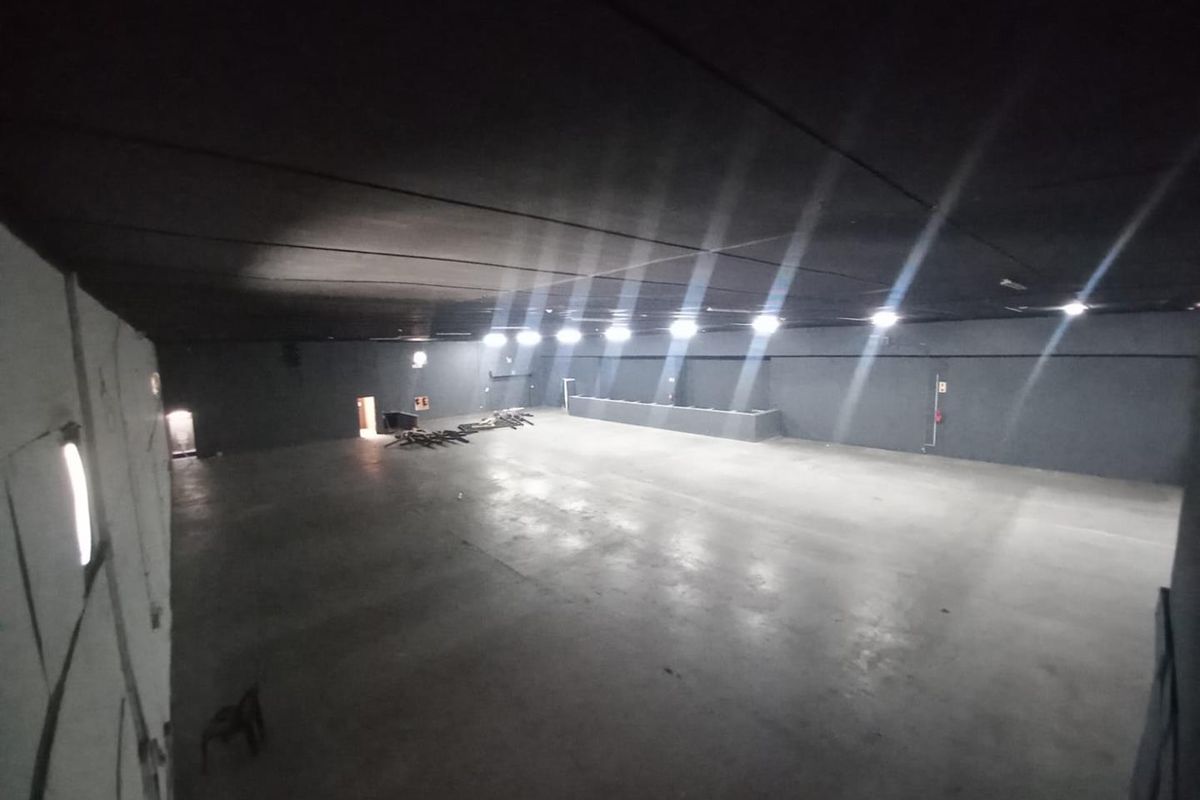 A large, open-plan industrial utility space featuring concrete flooring and recessed lighting, suitable for various commercial or storage applications.