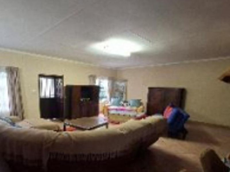 A spacious living room featuring tiled flooring and coved ceiling details, providing a neutral base for potential interior updates.