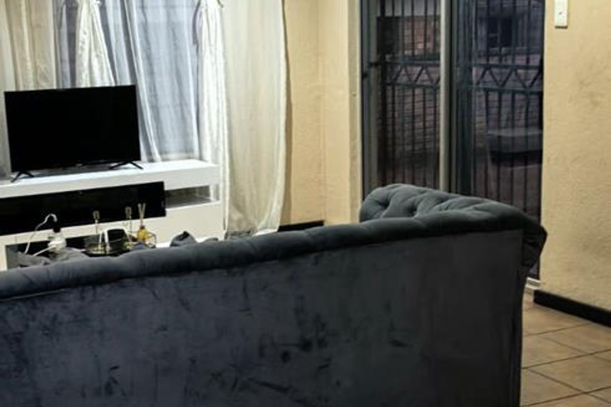 A living room featuring tiled flooring, recessed lighting, and a sliding glass door providing access to the exterior.