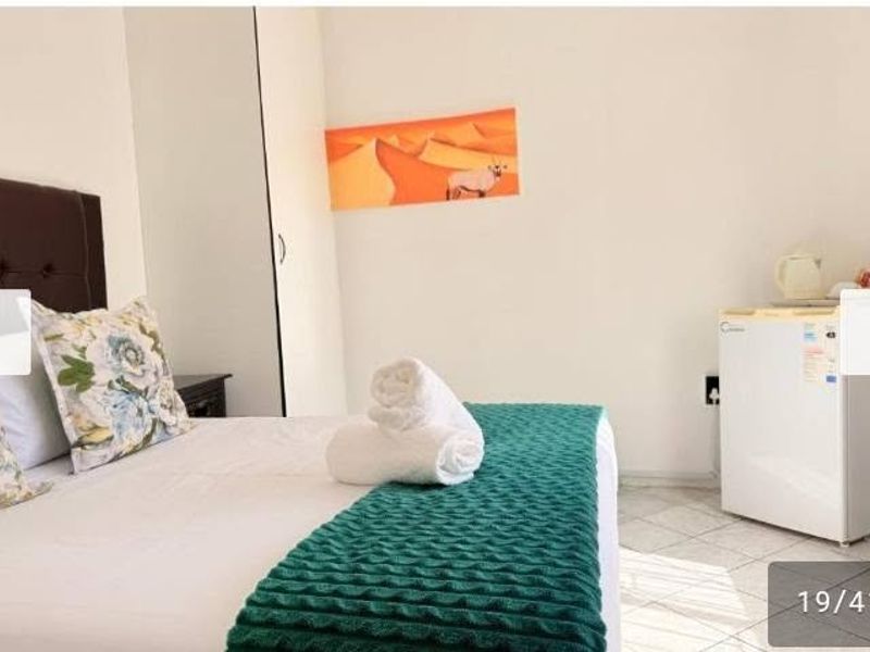 A bedroom featuring tiled flooring and a built-in wardrobe, providing a functional and simple living space.