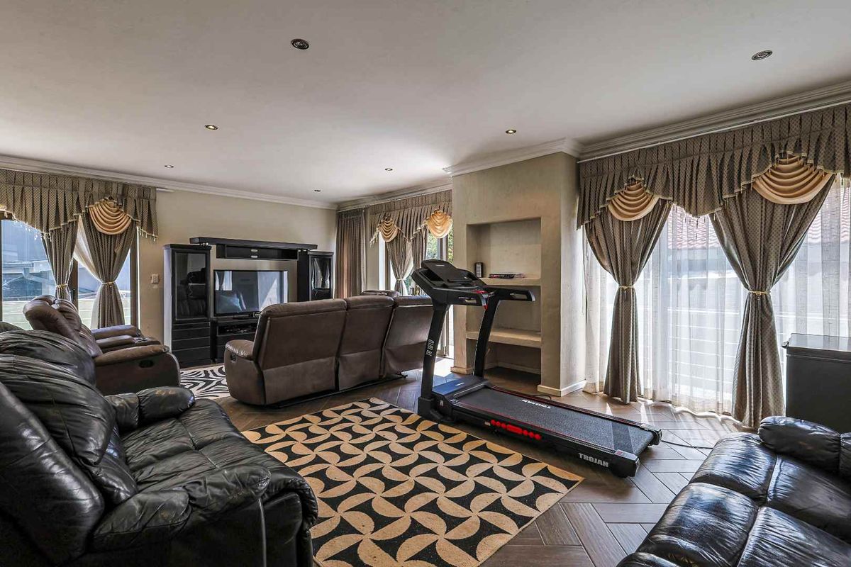 Spacious living room featuring tiled flooring, recessed ceiling lighting, and large glass sliding doors providing access to the outdoor area.