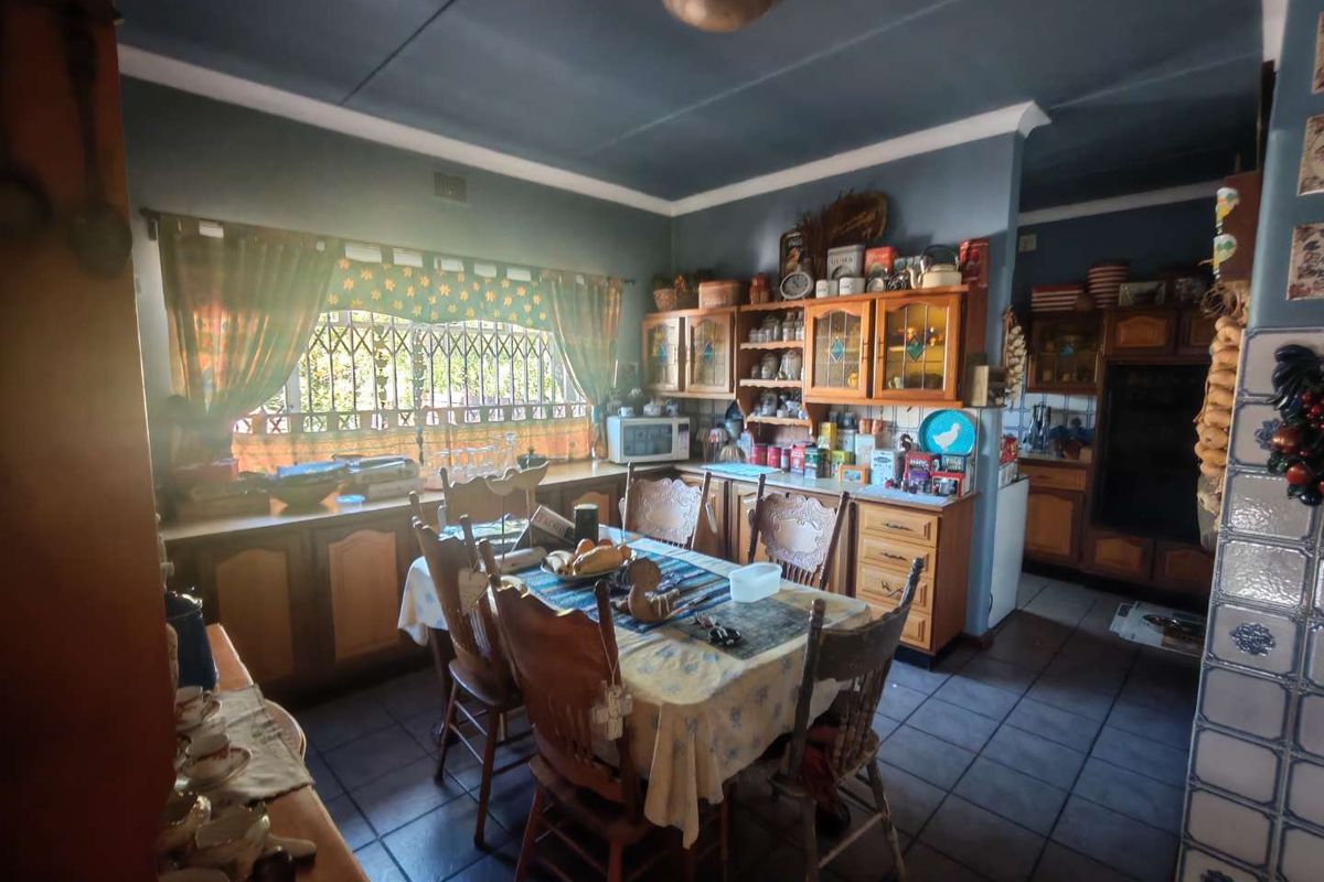 A traditional kitchen featuring wooden cabinetry, tiled flooring, and a dedicated dining area, offering a functional space with classic design elements.