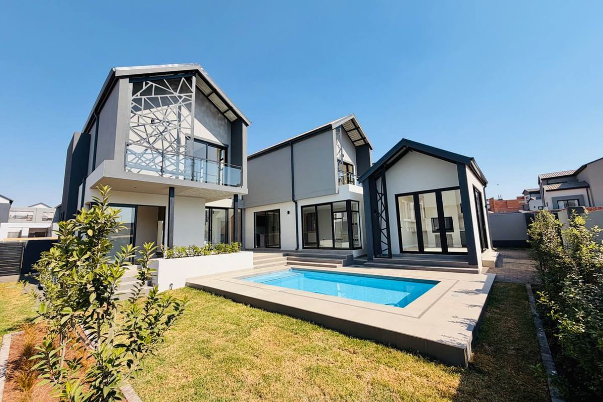 Modern rear exterior view featuring a swimming pool, paved patio area, and contemporary multi-level architecture with large glass sliding doors.