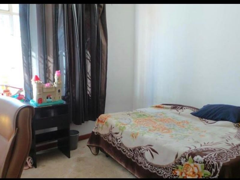 A standard bedroom featuring a window with curtain rails, providing a functional space for rest.