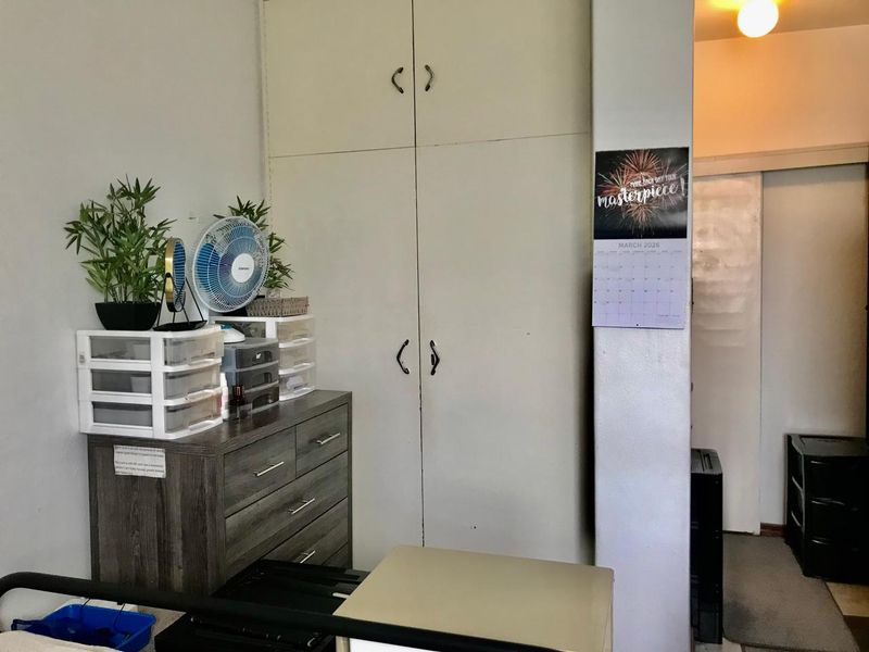 A bedroom interior featuring functional built-in cupboards providing ample storage space.