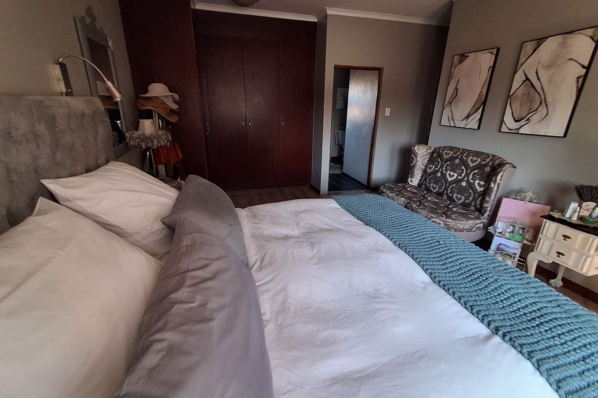 A bedroom featuring built-in wooden cupboards and neutral wall tones, providing a functional and comfortable sleeping space.