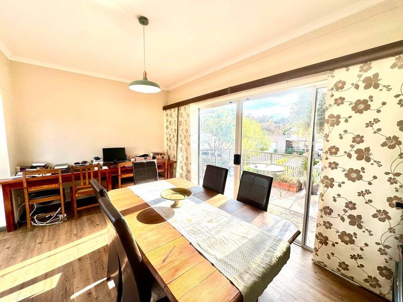 Dining room featuring laminate flooring, a pendant light, and large sliding glass doors providing access to an outdoor patio area.