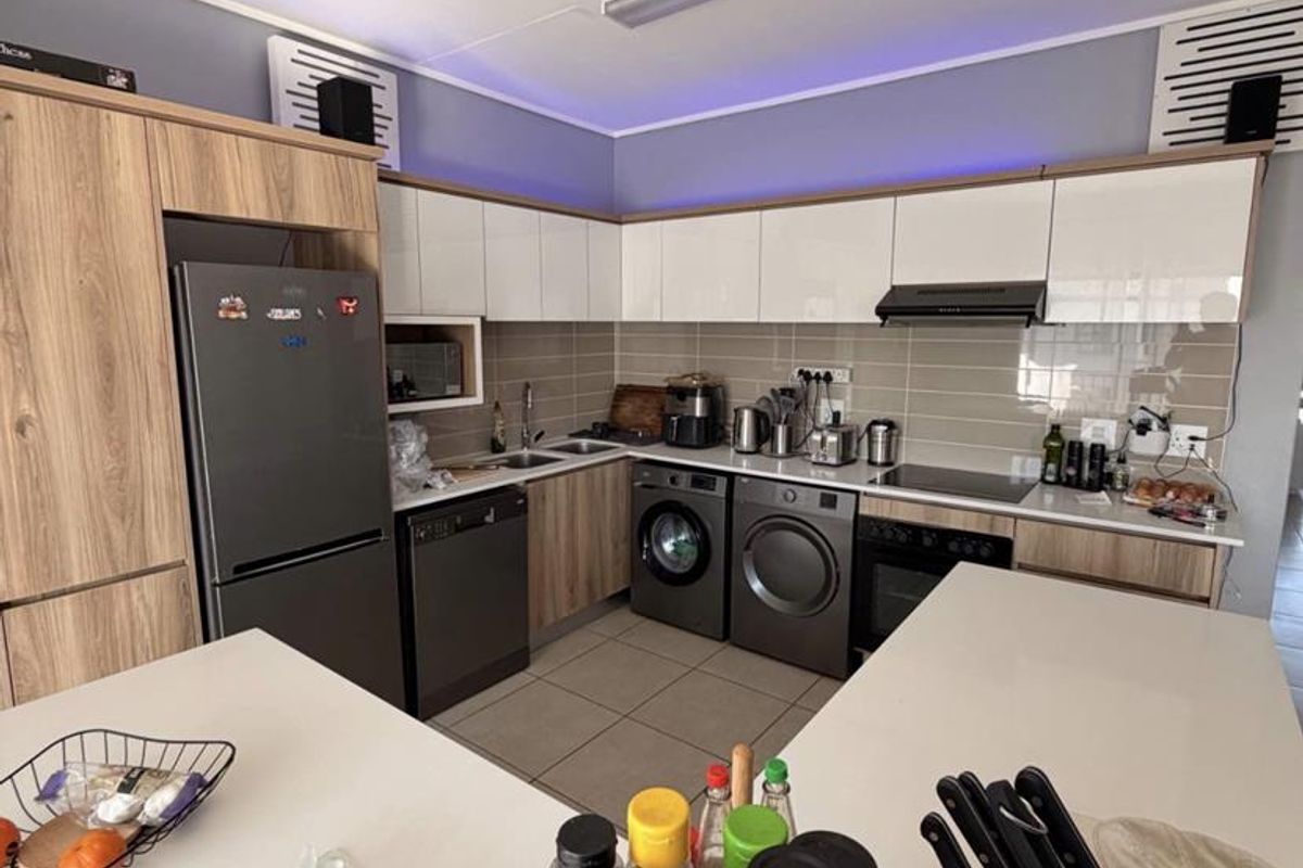 Modern kitchen featuring sleek cabinetry, stone countertops, integrated appliances, and a functional layout with a central island.