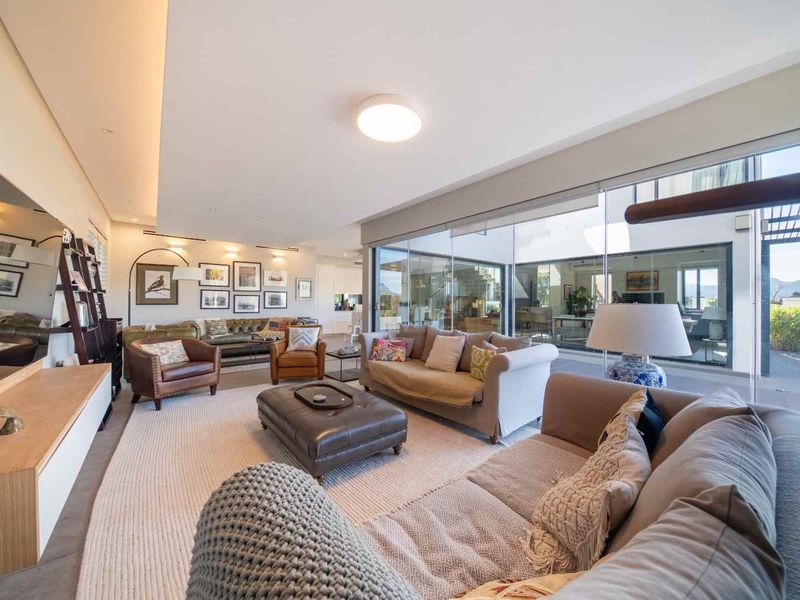 Spacious, modern living room featuring large glass sliding doors that provide seamless indoor-outdoor flow and abundant natural light.