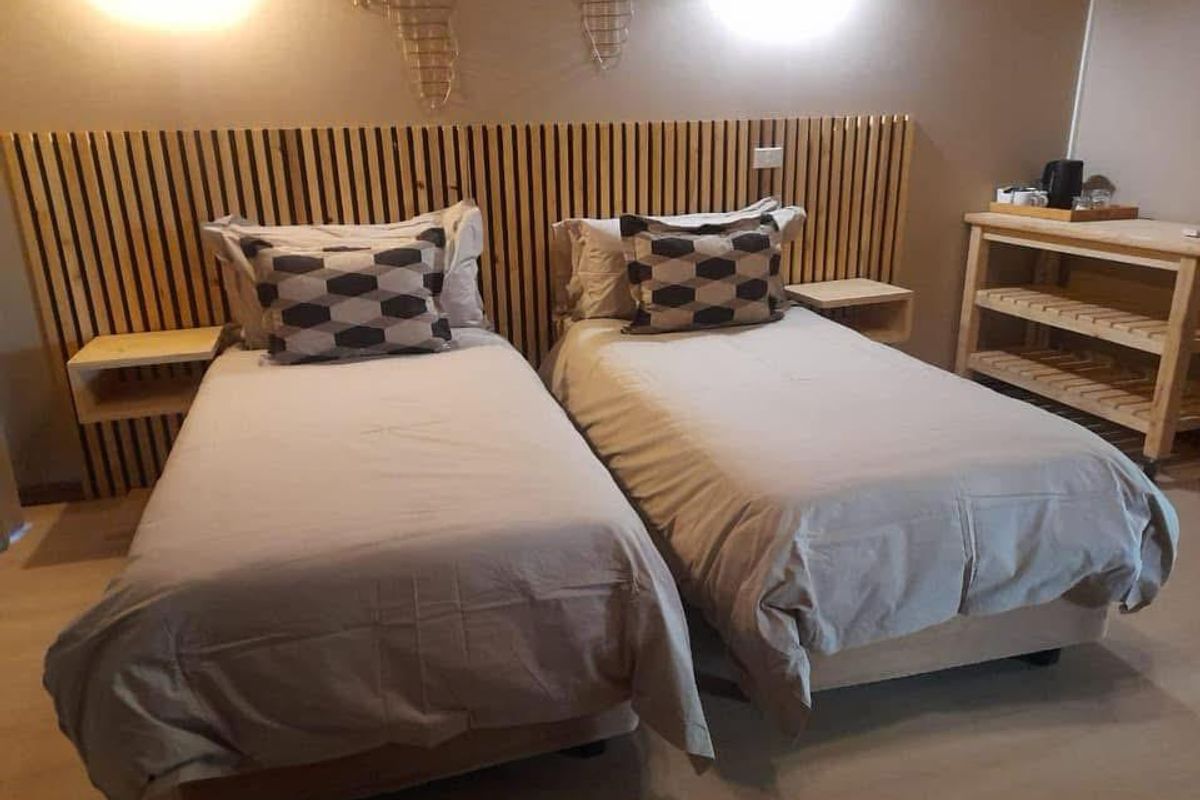 A well-maintained bedroom featuring a custom slatted timber headboard with integrated wall-mounted bedside shelves and warm wall sconce lighting.