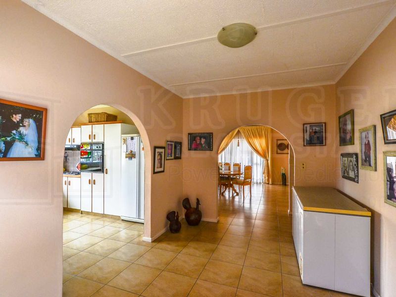Open plan living area featuring tiled flooring and arched transitions connecting the kitchen and dining space.