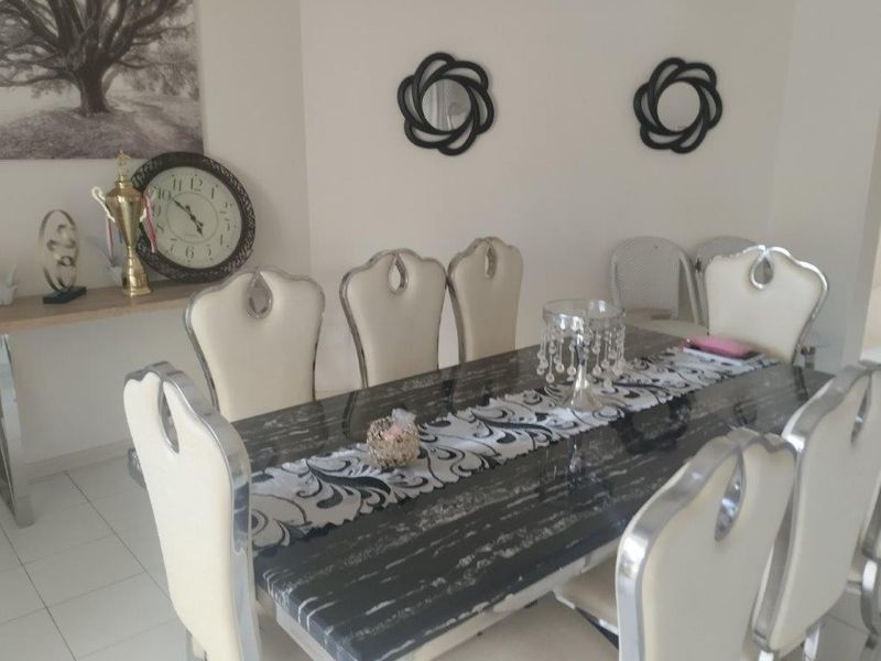 A dining room area featuring tiled flooring and neutral wall finishes, suitable for family meals and entertaining.