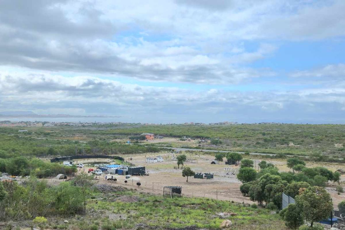 An elevated aerial view of the farm property, showcasing the expansive landscape, natural vegetation, and surrounding rural terrain.