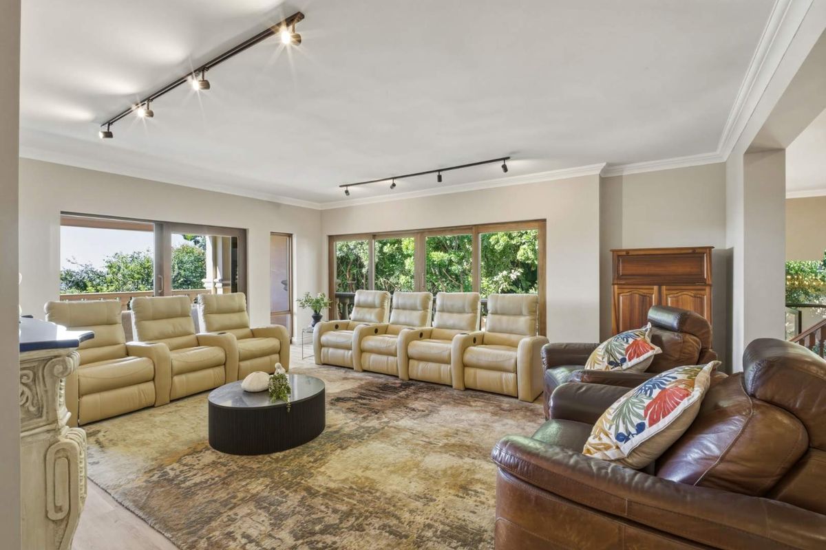 Spacious living room featuring large sliding glass doors, recessed track lighting, and neutral wall finishes, offering a bright and airy atmosphere.
