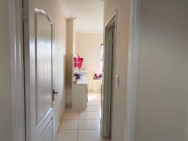 A functional hallway featuring tiled flooring and neutral walls, providing access to adjacent rooms within the apartment.