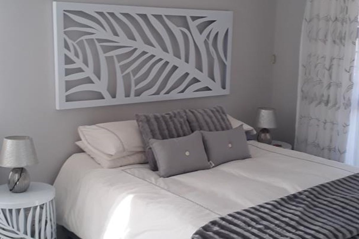 A well-maintained bedroom featuring neutral wall tones and clean tiled flooring, offering a bright and comfortable living space.