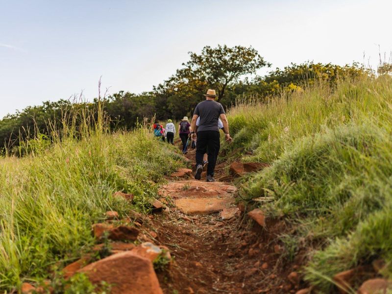 A natural walking trail winding through the grassy, undeveloped landscape of the residential property.