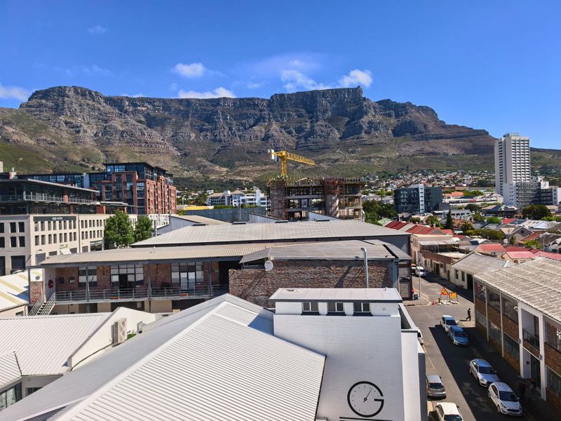 An elevated urban view showcasing the surrounding cityscape with a prominent mountain backdrop.