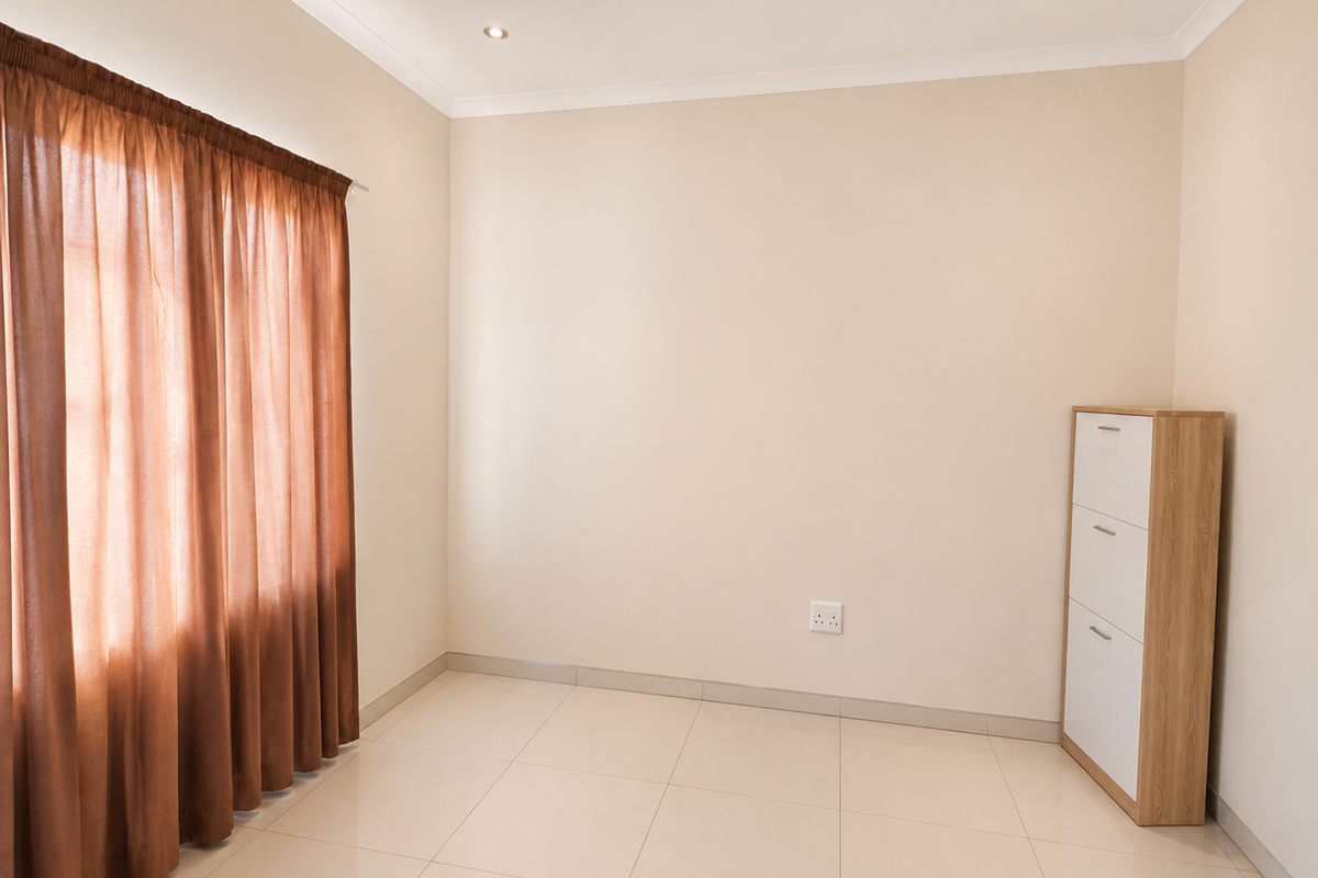 A bright, empty bedroom featuring neutral tiled flooring, recessed ceiling lighting, and clean wall finishes, ready for personalization.
