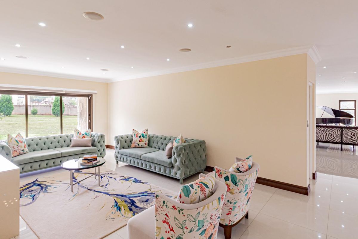 Spacious living area featuring polished tile flooring, recessed ceiling lighting, and large sliding glass doors providing access to the garden.