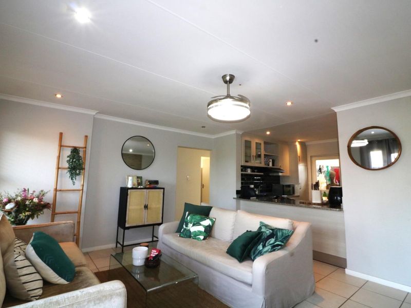 Open plan living area featuring tiled floors, recessed lighting, and a breakfast bar connecting to the kitchen space.