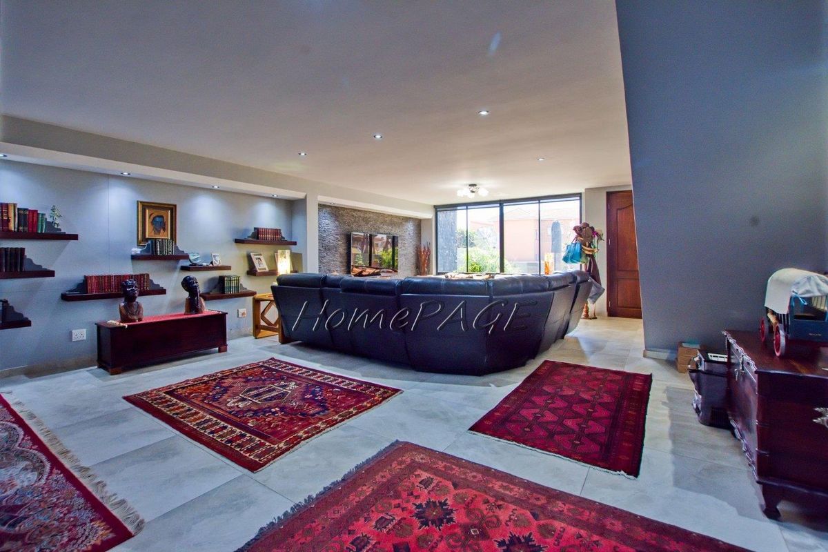 Spacious living room featuring a stone accent wall, recessed downlighting, and large sliding glass doors that provide ample natural light.