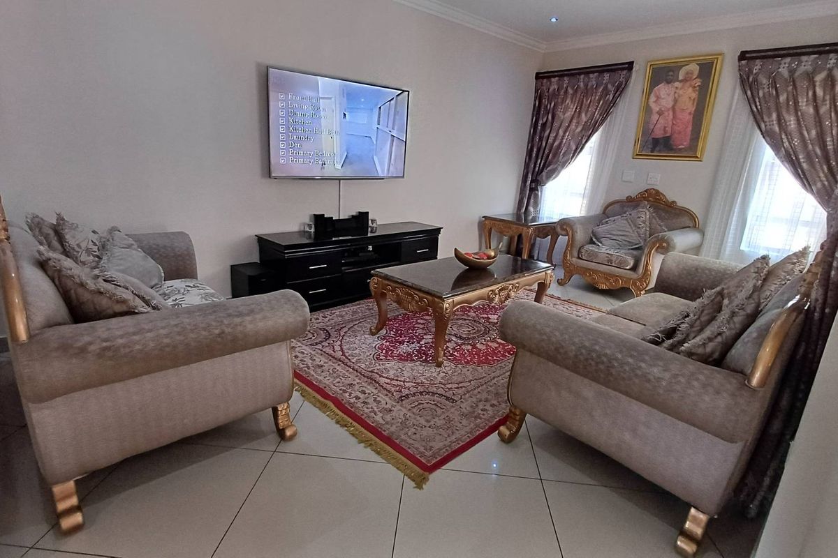 A well-maintained living room featuring tiled flooring, recessed ceiling lighting, and large windows with decorative curtains.