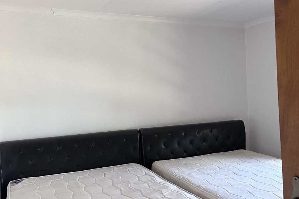 A bedroom featuring tiled flooring and a flush-mount ceiling light fixture.