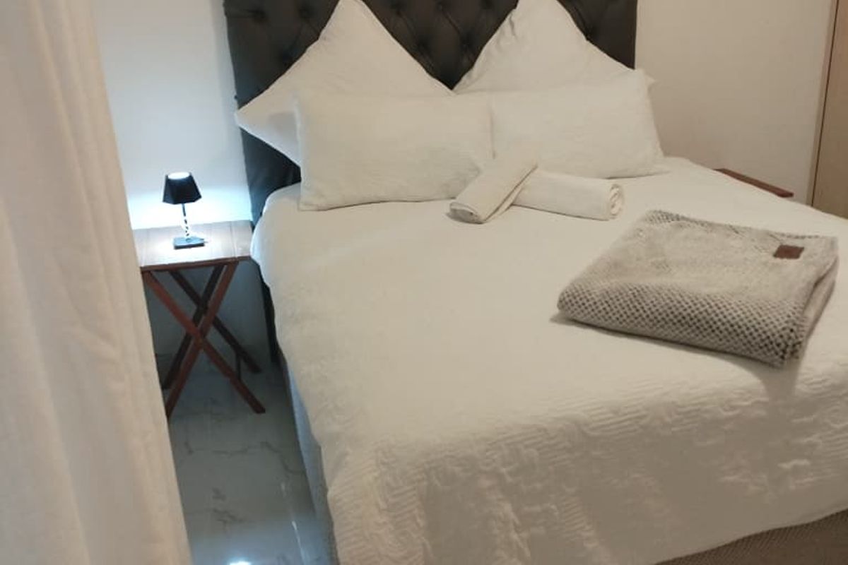 A bedroom featuring tiled flooring and neutral wall finishes, providing a clean and simple living space.