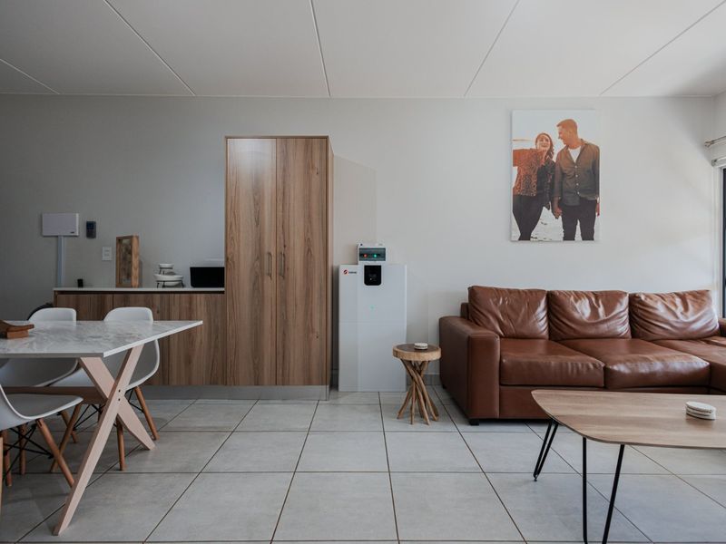 An open-plan living and dining area featuring neutral tiled flooring, modern built-in cabinetry, and ample natural light from the adjacent window.