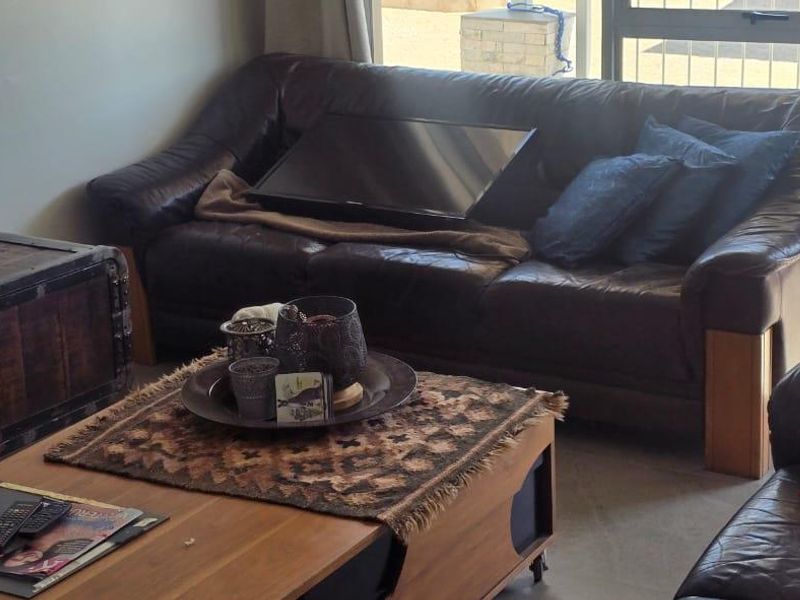 A living room area featuring a large sliding glass door providing natural light and access to the exterior.