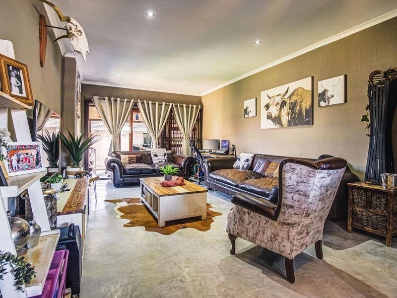 Spacious living room featuring polished concrete floors, recessed downlighting, and large sliding glass doors providing access to the outdoor patio area.