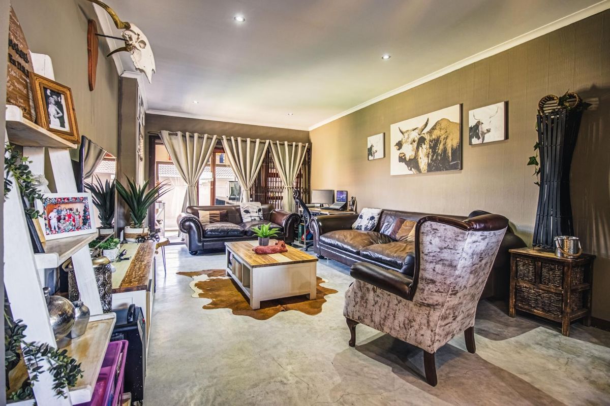 Spacious living room featuring polished concrete floors, recessed downlighting, and large sliding glass doors providing access to the outdoor patio area.