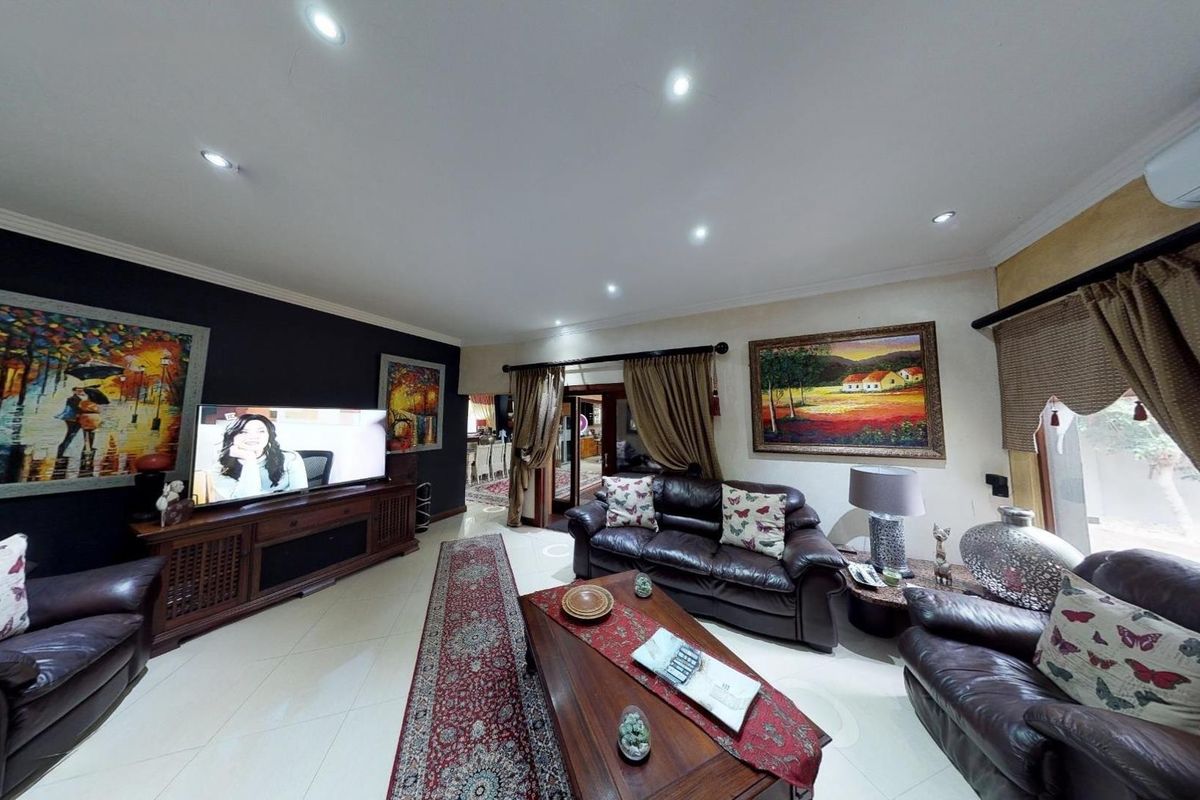 Spacious living room featuring tiled flooring, recessed downlighting, and a wall-mounted air conditioning unit, providing a comfortable and well-lit area for relaxation.