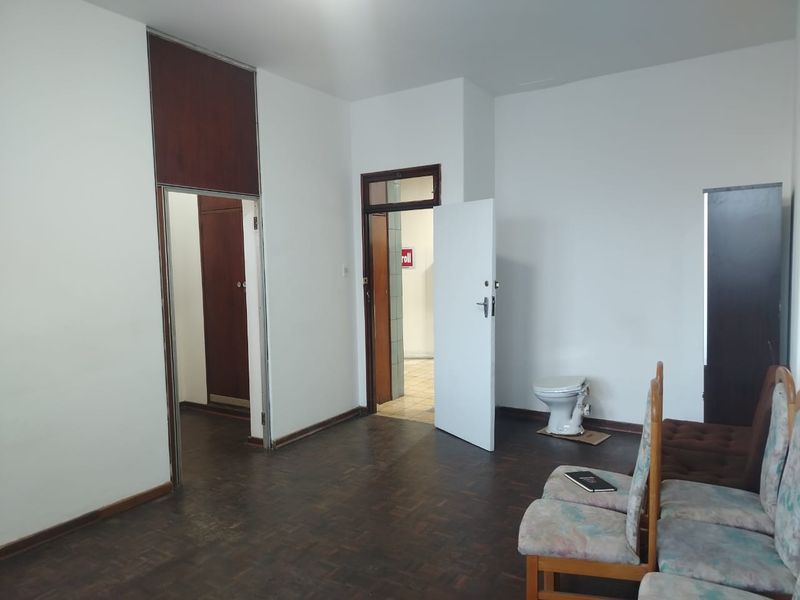 Bedroom featuring parquet flooring and a built-in cupboard, with an unusual inclusion of an exposed toilet fixture.