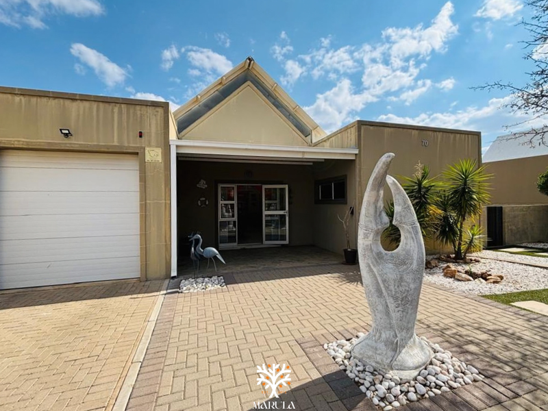 Front elevation of the property featuring a paved driveway, single garage, and a covered entrance area.