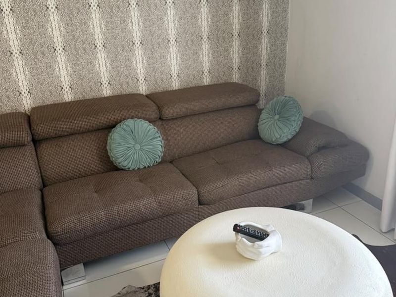 A living room area featuring tiled flooring and a decorative patterned feature wall.