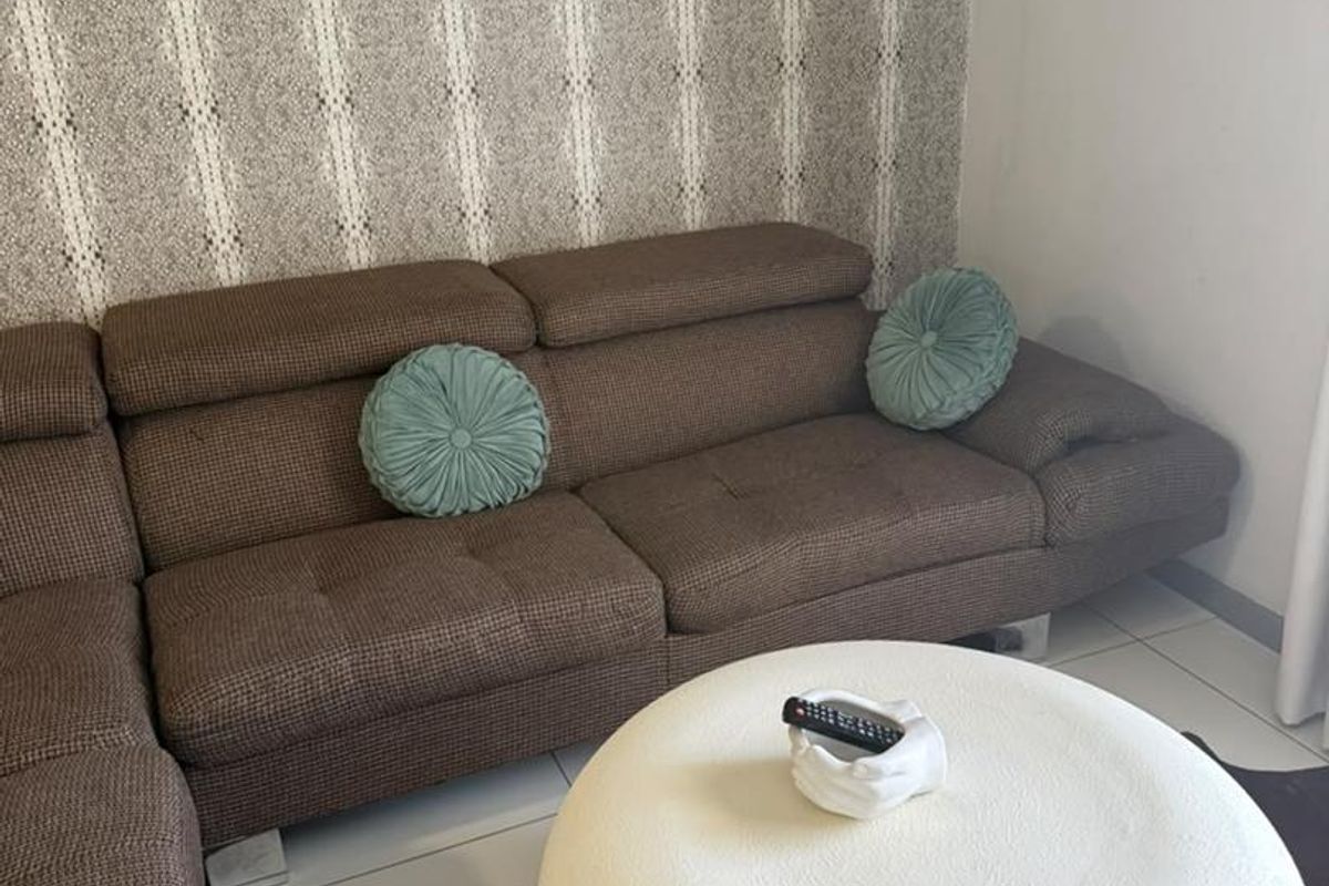 A living room area featuring tiled flooring and a decorative patterned feature wall.