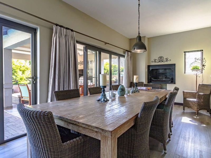 Spacious dining room featuring laminate flooring, a built-in fireplace, and large sliding glass doors providing seamless access to the outdoor patio area.